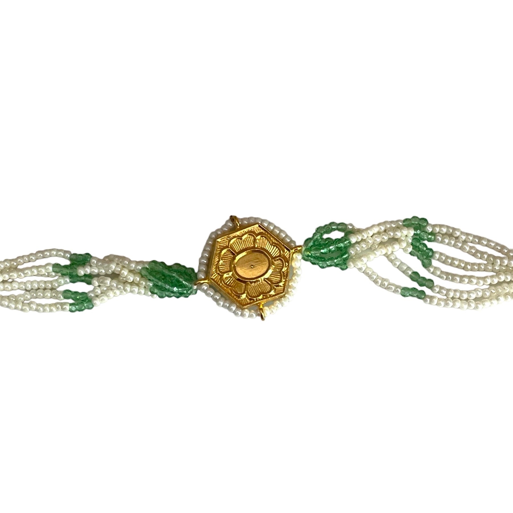 The Marguerite Bracelet features a bold hexagonal shape, surrounded by delicate Kundan stones and lustrous pearls. Elegant green enamel hand-painted to perfection brings a striking contrast to the bracelet, while green and white chains on either side create a harmonious balance of color and texture.