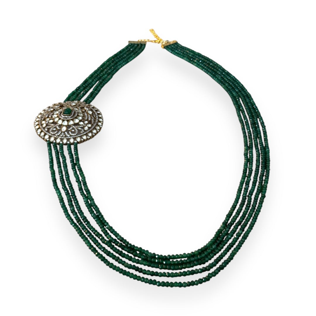 Introducing the Édith Necklace, a captivating fusion of elegance and bold artistry, named in honor of the iconic Édith Piaf. This luxurious necklace features a round pendant crafted with a stunning green jade stone necklace, framed in 18k gold dipped vintage elegance to evoke timeless Parisian glamour. Worn off-center, like an elegant brooch, the pendant creates a striking, asymmetrical silhouette that drapes with effortless grace, offering a fresh twist on classic jewelry.