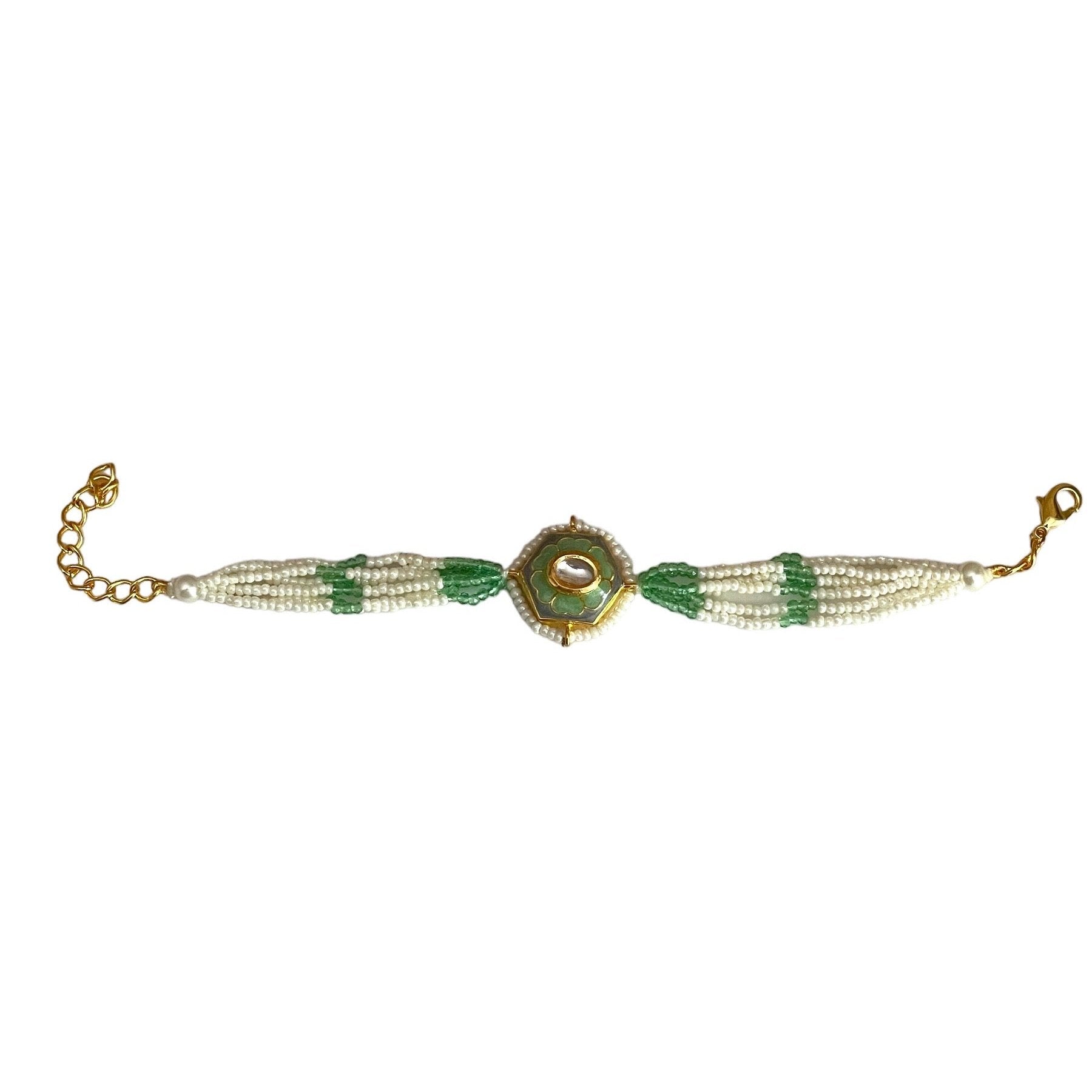 The Marguerite Bracelet features a bold hexagonal shape, surrounded by delicate Kundan stones and lustrous pearls. Elegant green enamel hand-painted to perfection brings a striking contrast to the bracelet, while green and white chains on either side create a harmonious balance of color and texture.