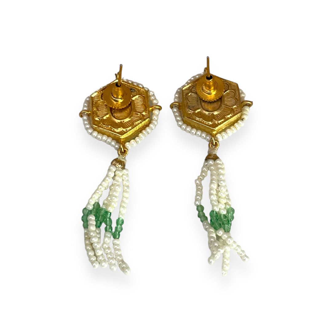 Irma Earrings are a stunning fusion of timeless craftsmanship and contemporary elegance. These earrings feature a bold hexagonal shape, adorned with luxurious green enamel and intricate Kundan stones, creating a captivating interplay of light and color.