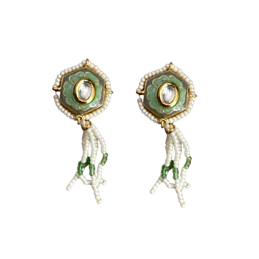 Irma Earrings are a stunning fusion of timeless craftsmanship and contemporary elegance. These earrings feature a bold hexagonal shape, adorned with luxurious green enamel and intricate Kundan stones, creating a captivating interplay of light and color.