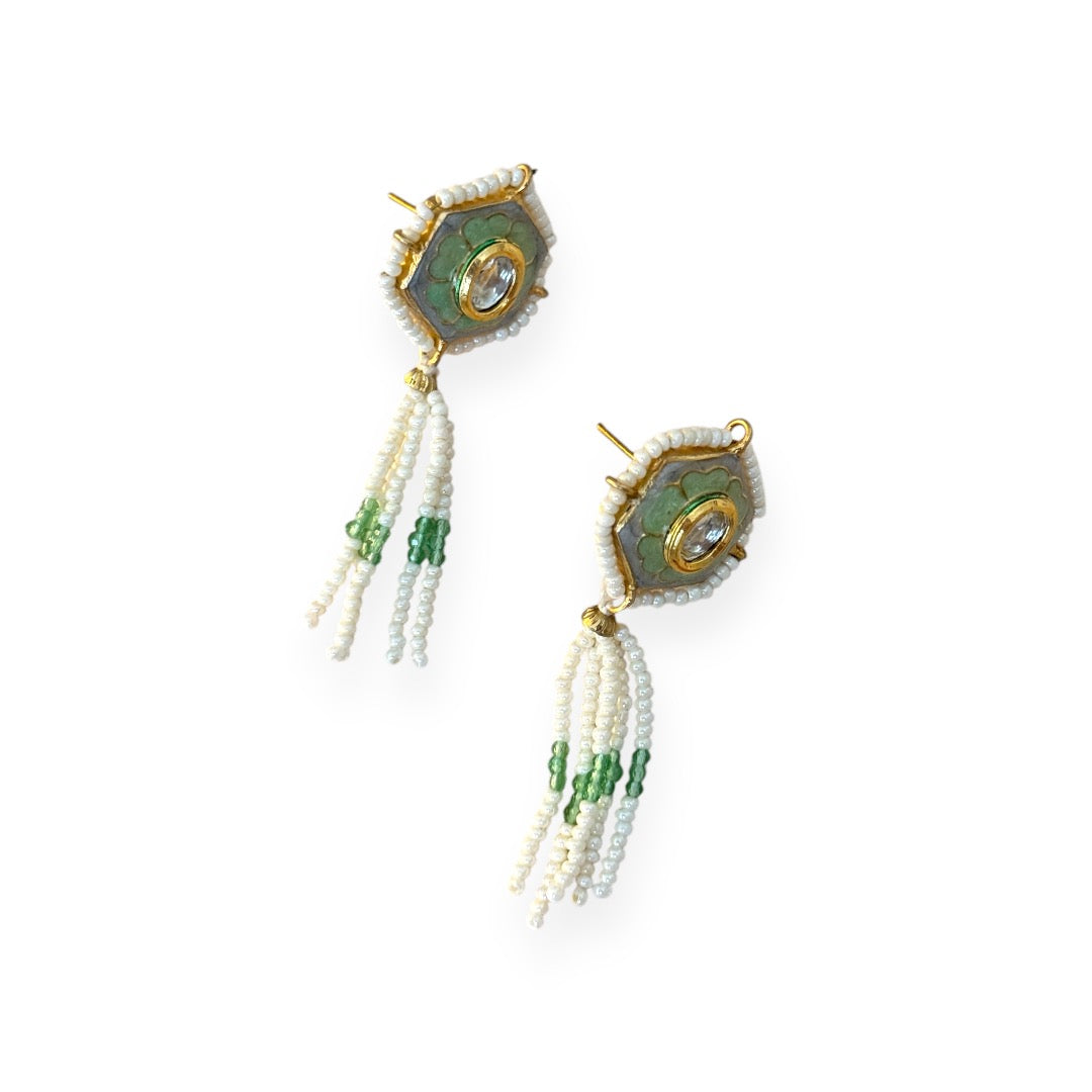Irma Earrings are a stunning fusion of timeless craftsmanship and contemporary elegance. These earrings feature a bold hexagonal shape, adorned with luxurious green enamel and intricate Kundan stones, creating a captivating interplay of light and color.