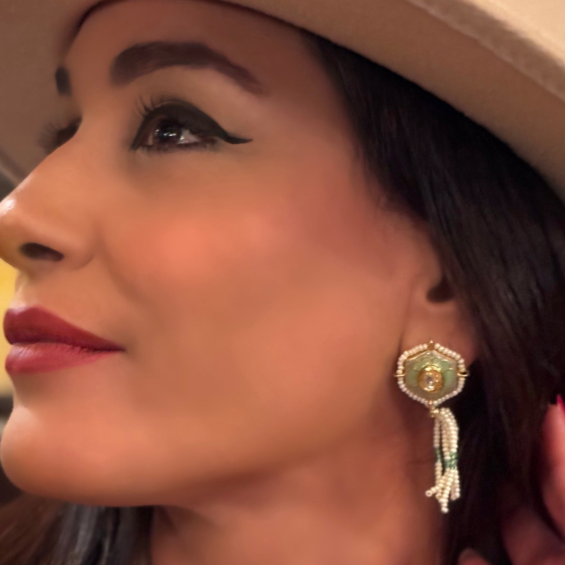 Irma Earrings are a stunning fusion of timeless craftsmanship and contemporary elegance. These earrings feature a bold hexagonal shape, adorned with luxurious green enamel and intricate Kundan stones, creating a captivating interplay of light and color.