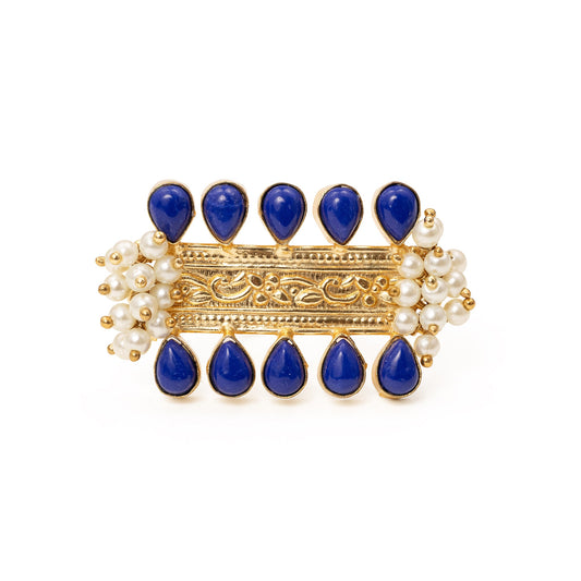 Ring with blue stones and gold accents on a white background