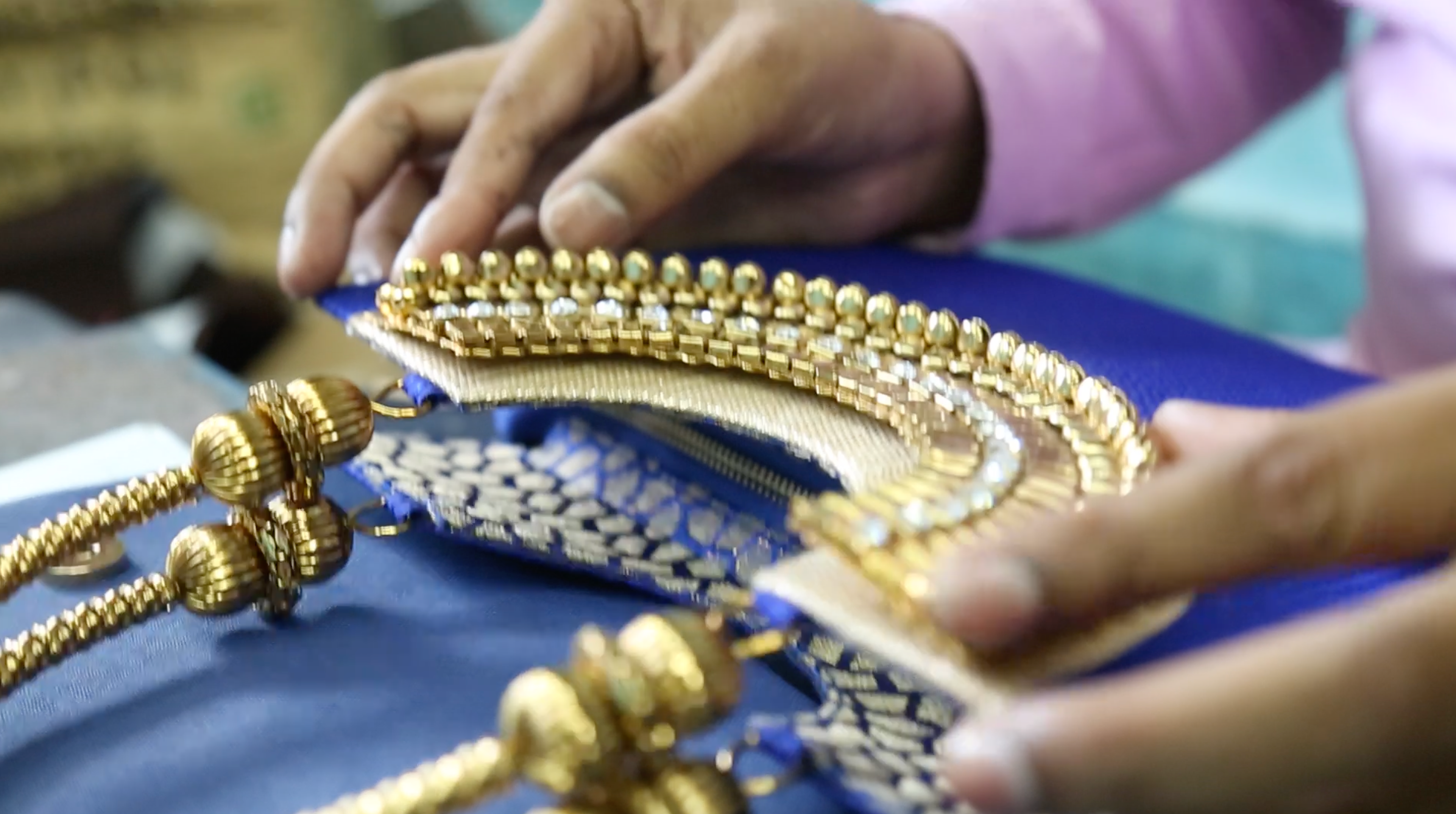 Close-up of hands holding a decorative gold and blue item