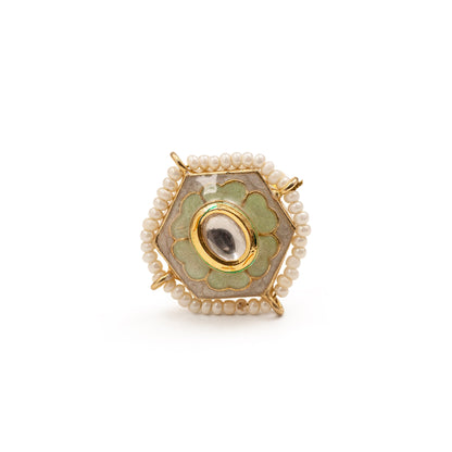 Decorative ring with green gemstone and pearl accents on a white background