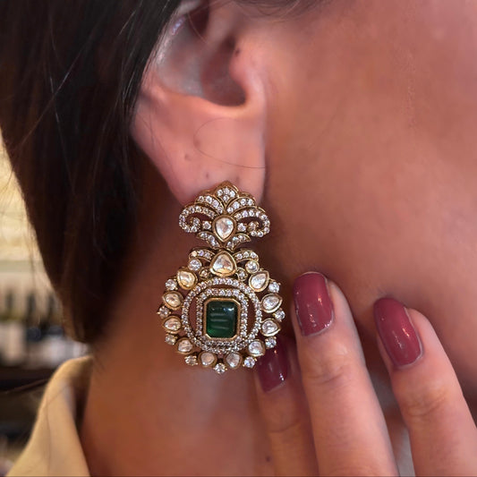 Introducing the Jane Earrings, a dazzling homage to the iconic Can-can dancer Jane Avril and the spirited elegance of Parisian cabaret. These exquisite earrings feature a stunning green center stone, surrounded by a delicate halo of Kundan stones and set in 18k gold dipped vintage vibe.