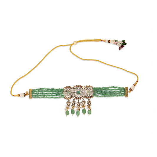 Decorative choker with green beads and gold accents on a white background