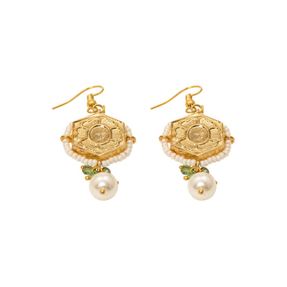 Pair of gold earrings with pearl drops on a white background