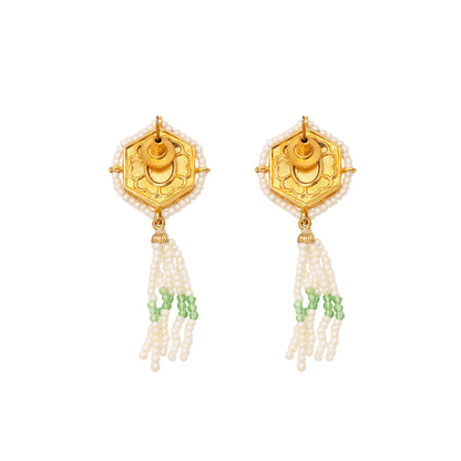 Gold earrings with pearl and green bead decorations on a white background