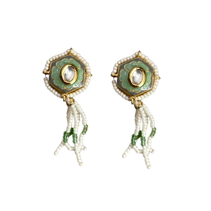 Irma Earrings are a stunning fusion of timeless craftsmanship and contemporary elegance. These earrings feature a bold hexagonal shape, adorned with luxurious green enamel and intricate Kundan stones, creating a captivating interplay of light and color. 