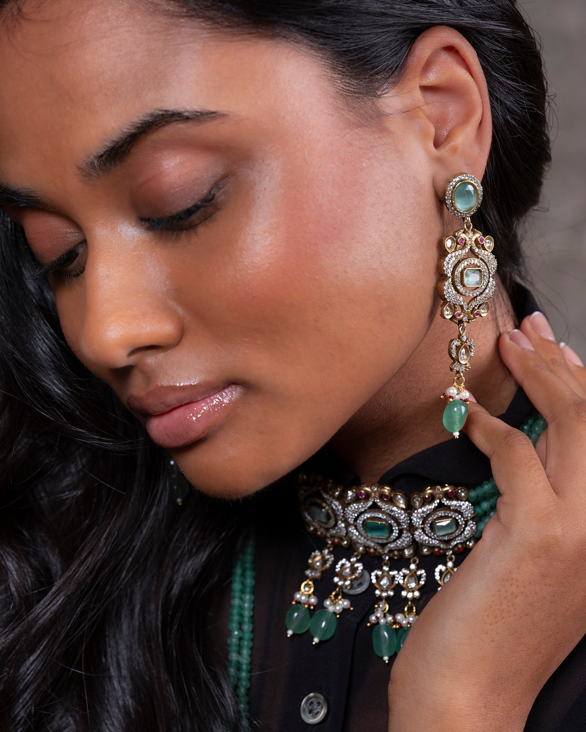 Close-up of a woman wearing ornate earrings and a matching necklace.