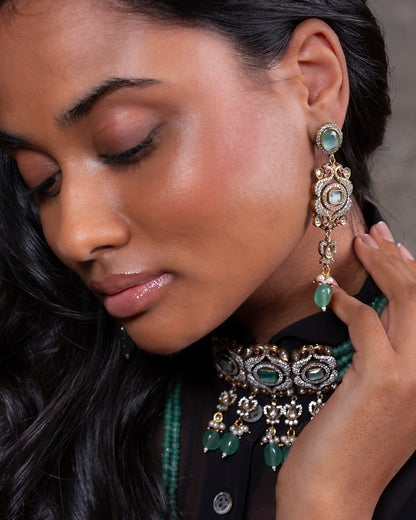Close-up of a woman wearing ornate earrings and a matching necklace.