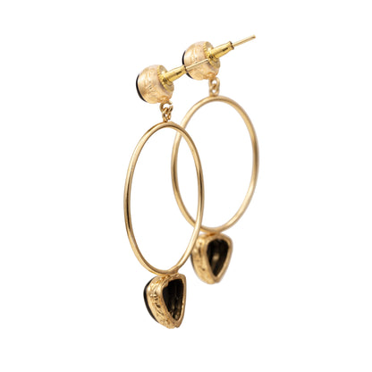 Gold hoop earrings with teardrop-shaped charms on a white background