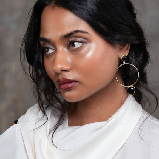 Model wearing black and gold earring 