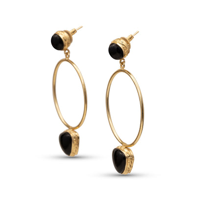 Gold hoop earrings with black stones on a white background