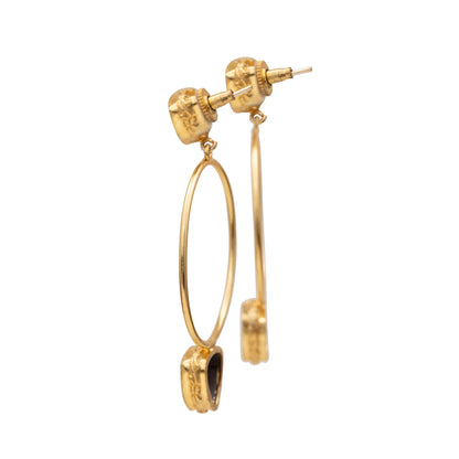 Gold hoop earrings with a central gemstone on a white background