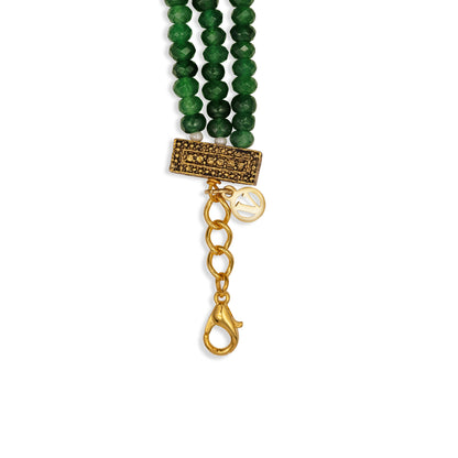 Green beaded bracelet with gold clasp on a white background