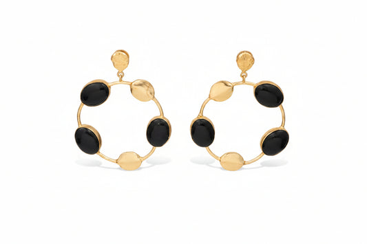 Gold hoop earrings with black stones on a white background