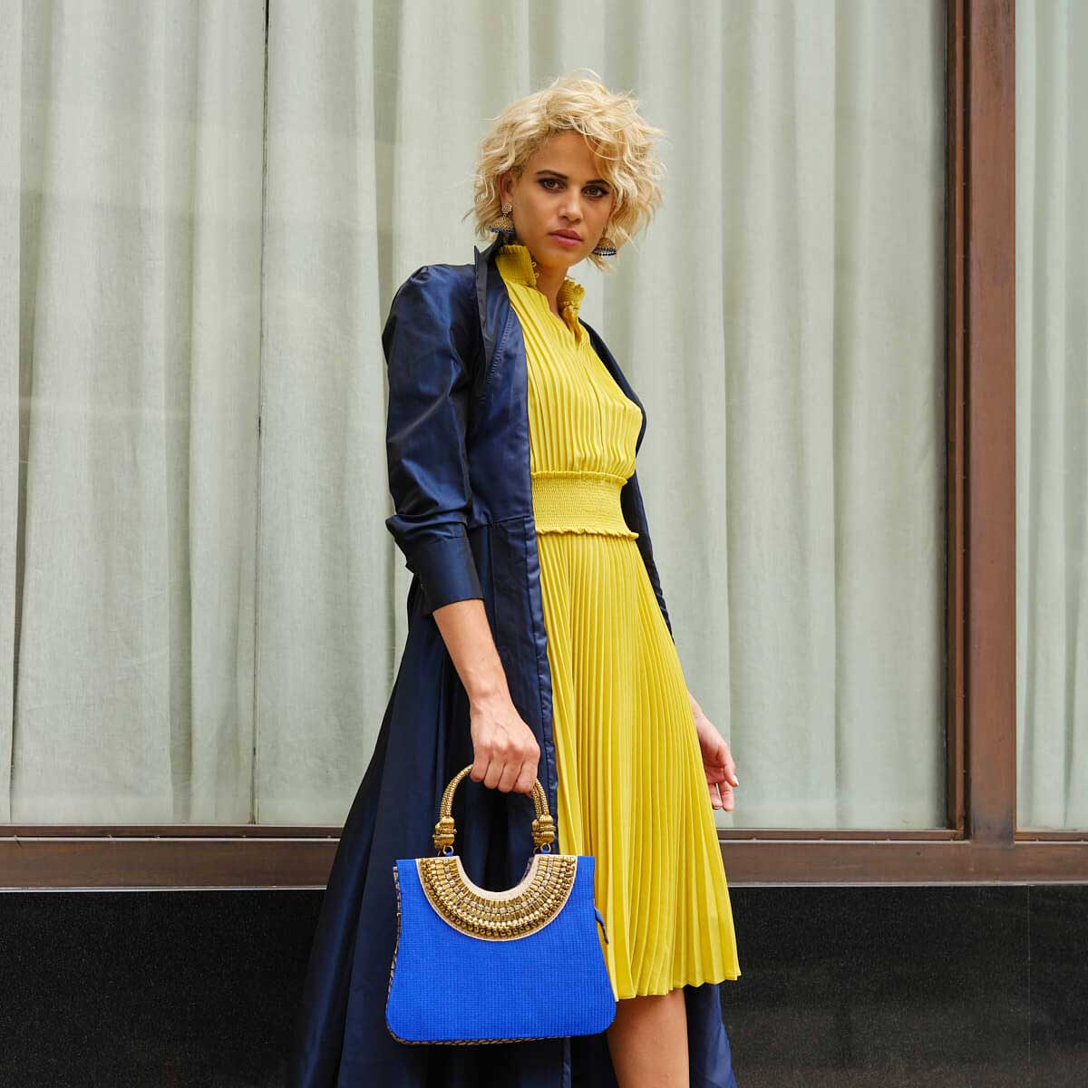 Suriya Mini tote blue and gold with ornate handles. As seen on ramp at NYFW 2021 and editorials. Model is carrying the big blue bag