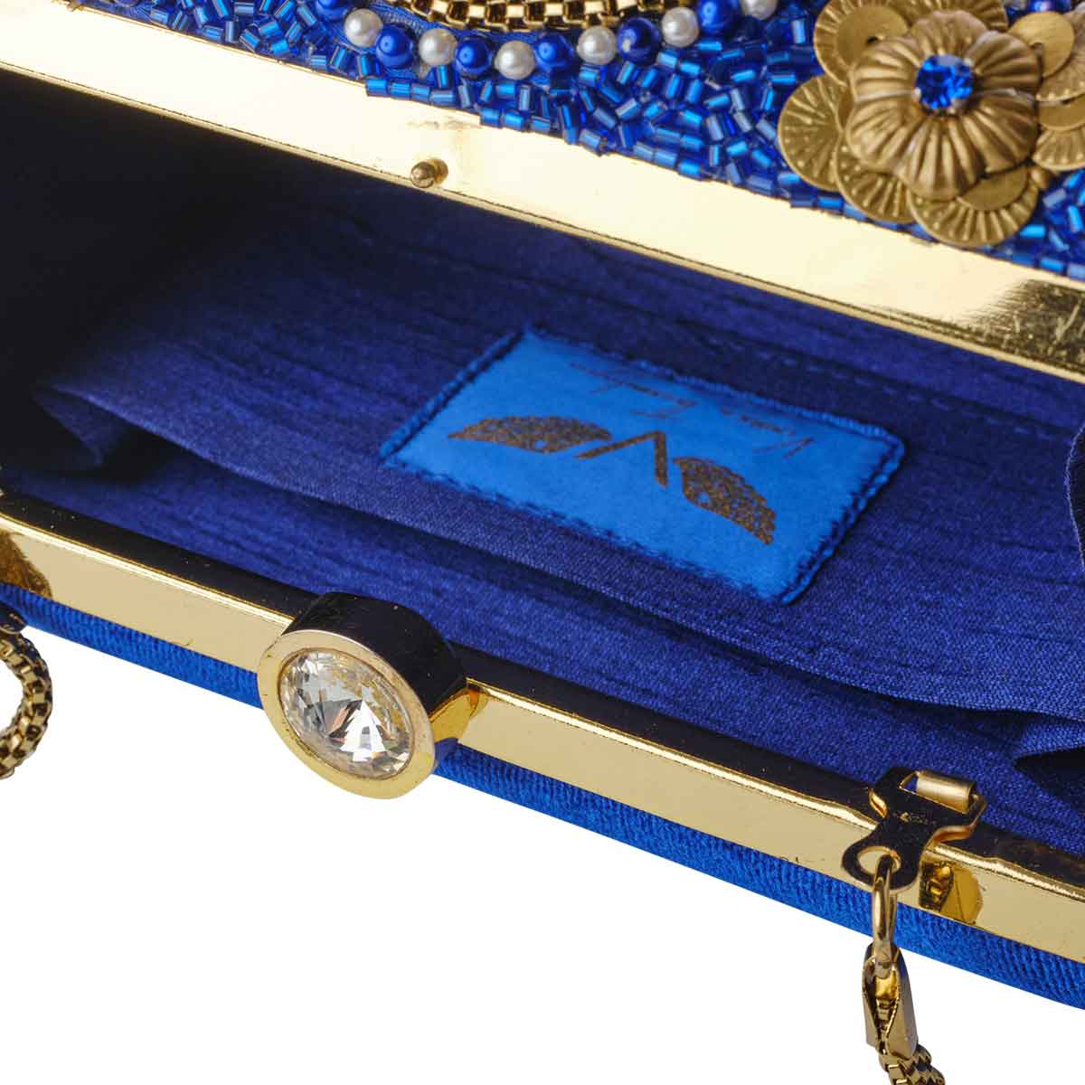 Inside view of blue and gold clutch, has a small pocket to put credit card etc inside. Big stone lock and chain visible. Aelia Clutch from Rani Collection by Veronica Tharmalingam